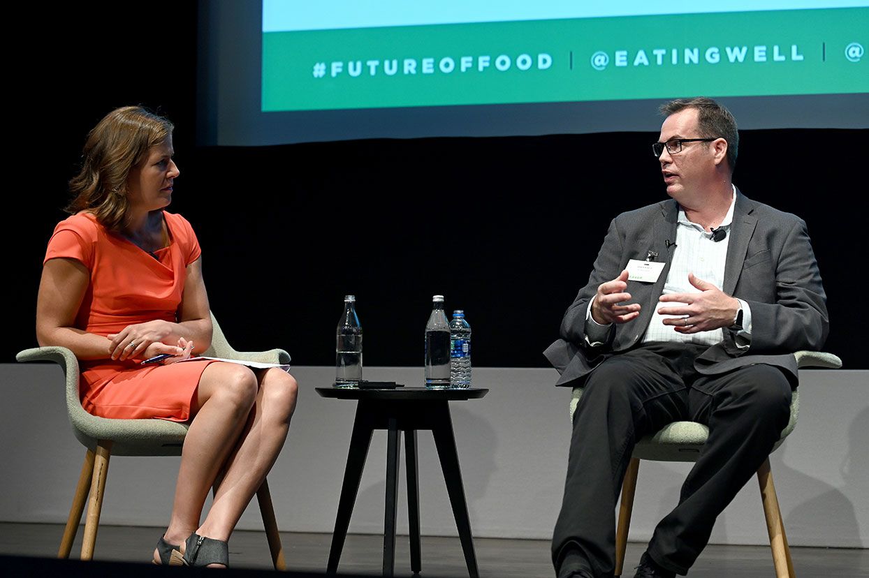 Jessie Price talks to GE's Chris Bissig on consumer technology in the kitchen, sitting on a stage with screen in background