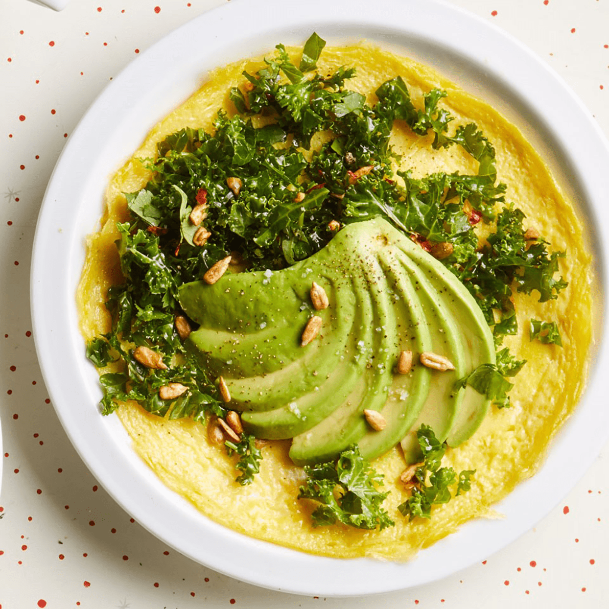 avocado and kale omelet on a white plate
