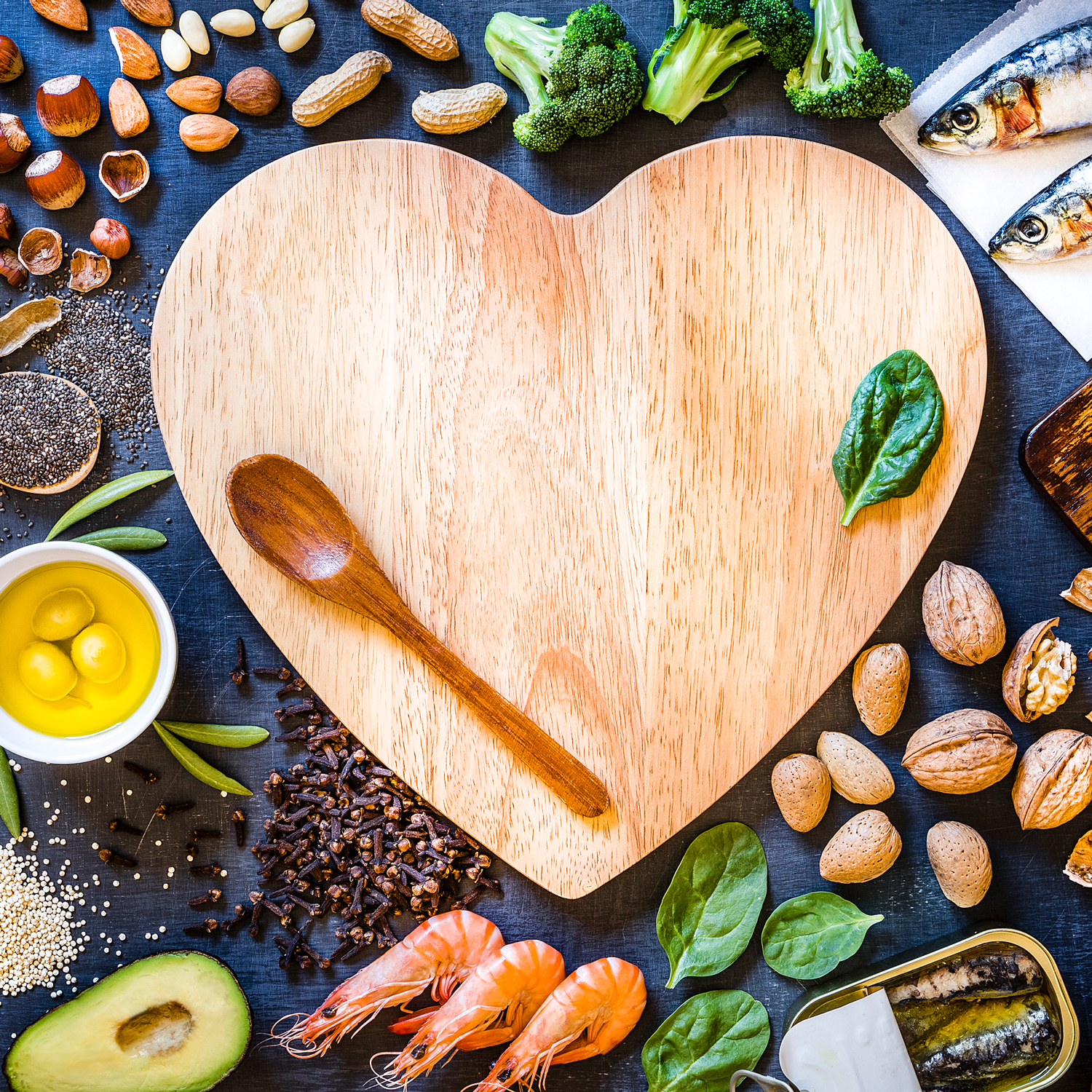 heart shaped cutting board with healthy foods surrounding it