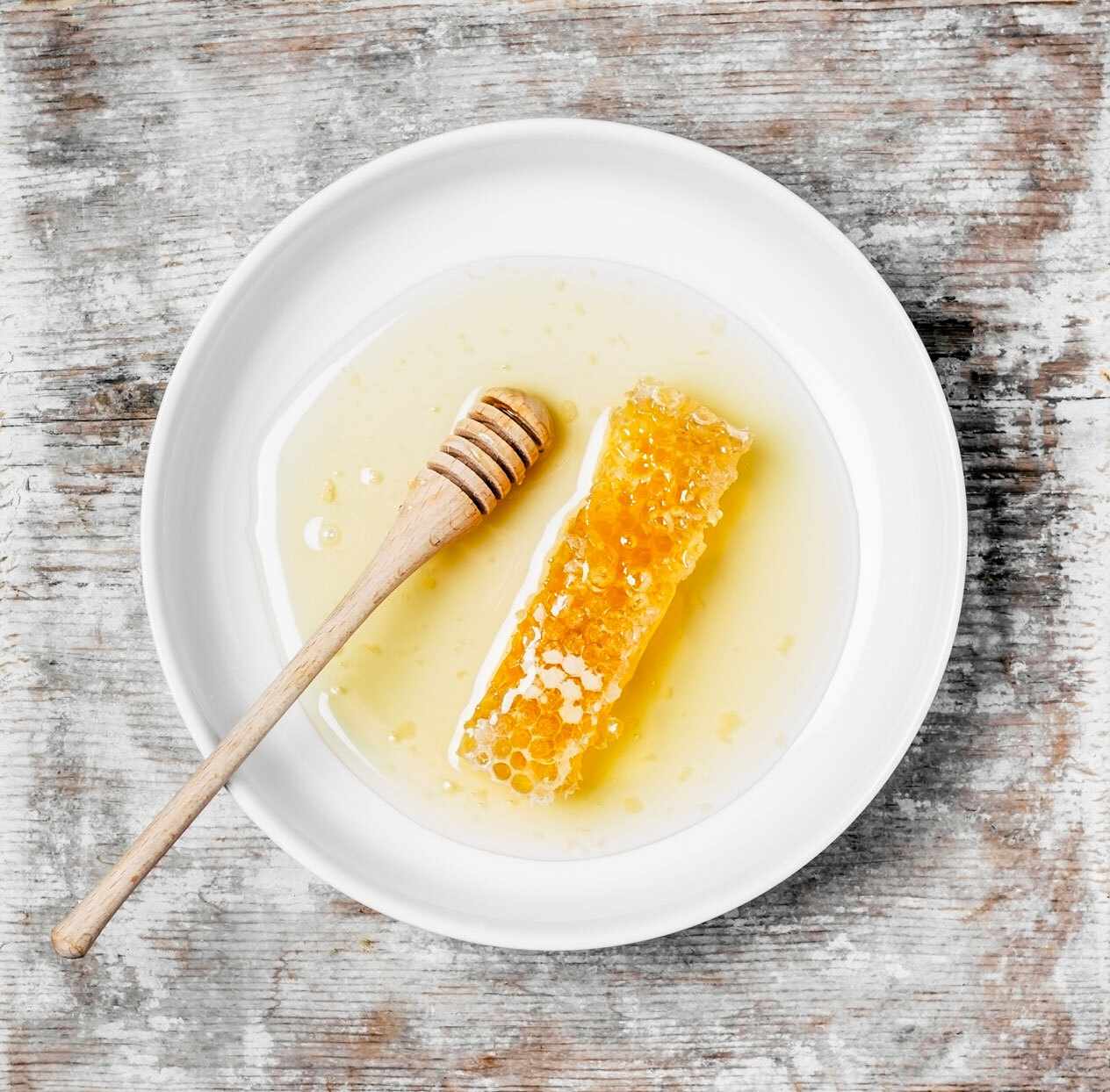 photo of honey and honeycomb on a white plate