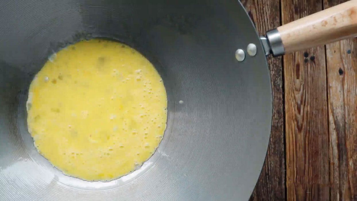 Scrambled eggs cooking in a wok.