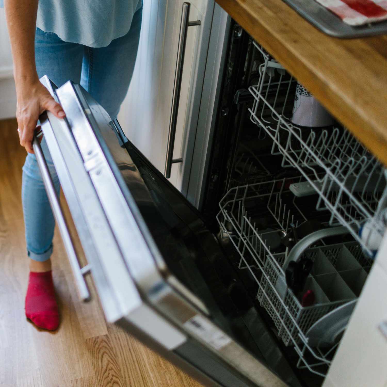 woman opening dishwasher