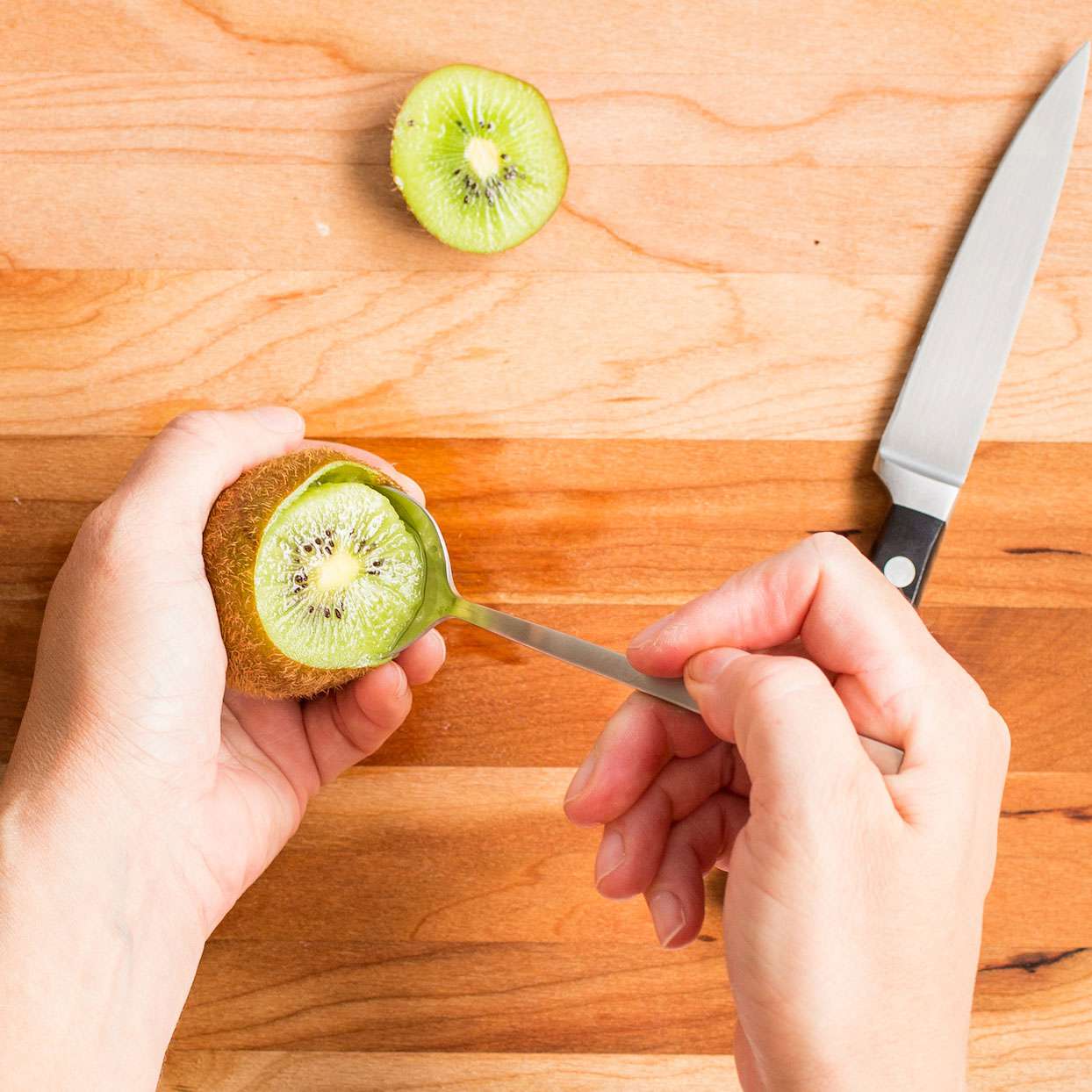 scooping kiwi out of skin with a spoon