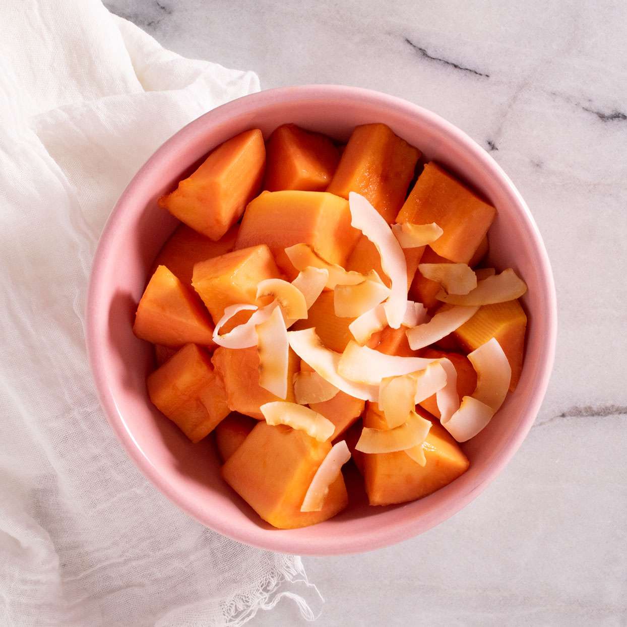 cubed papaya with coconut flakes