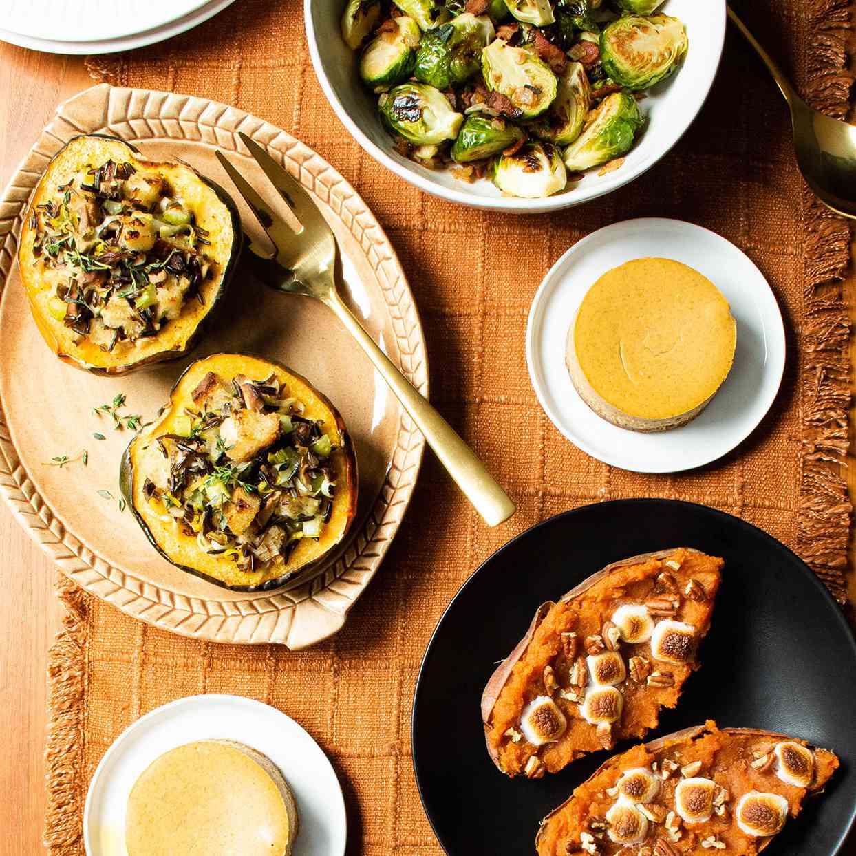 Table set with sweet potatoes, pumpkin cheesecake, stuffed squash and Brussels sprouts