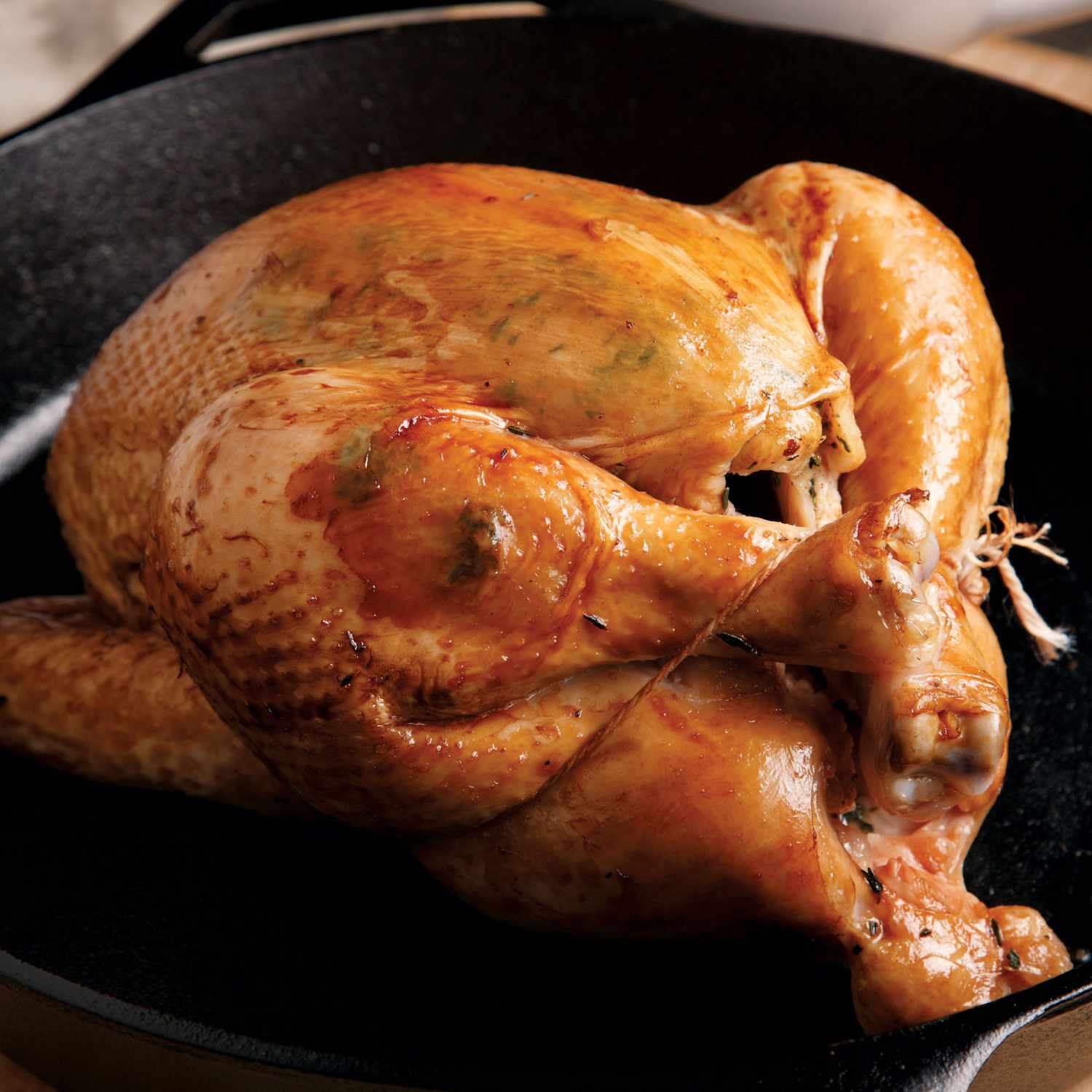 close-up of whole roasted chicken in a black cast-iron skillet