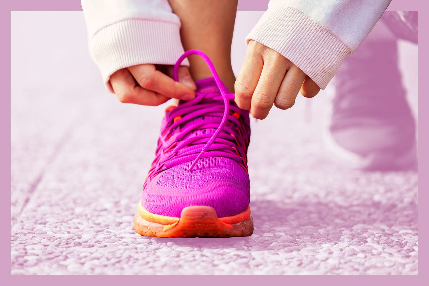 Hands of young woman lacing pink sneakers