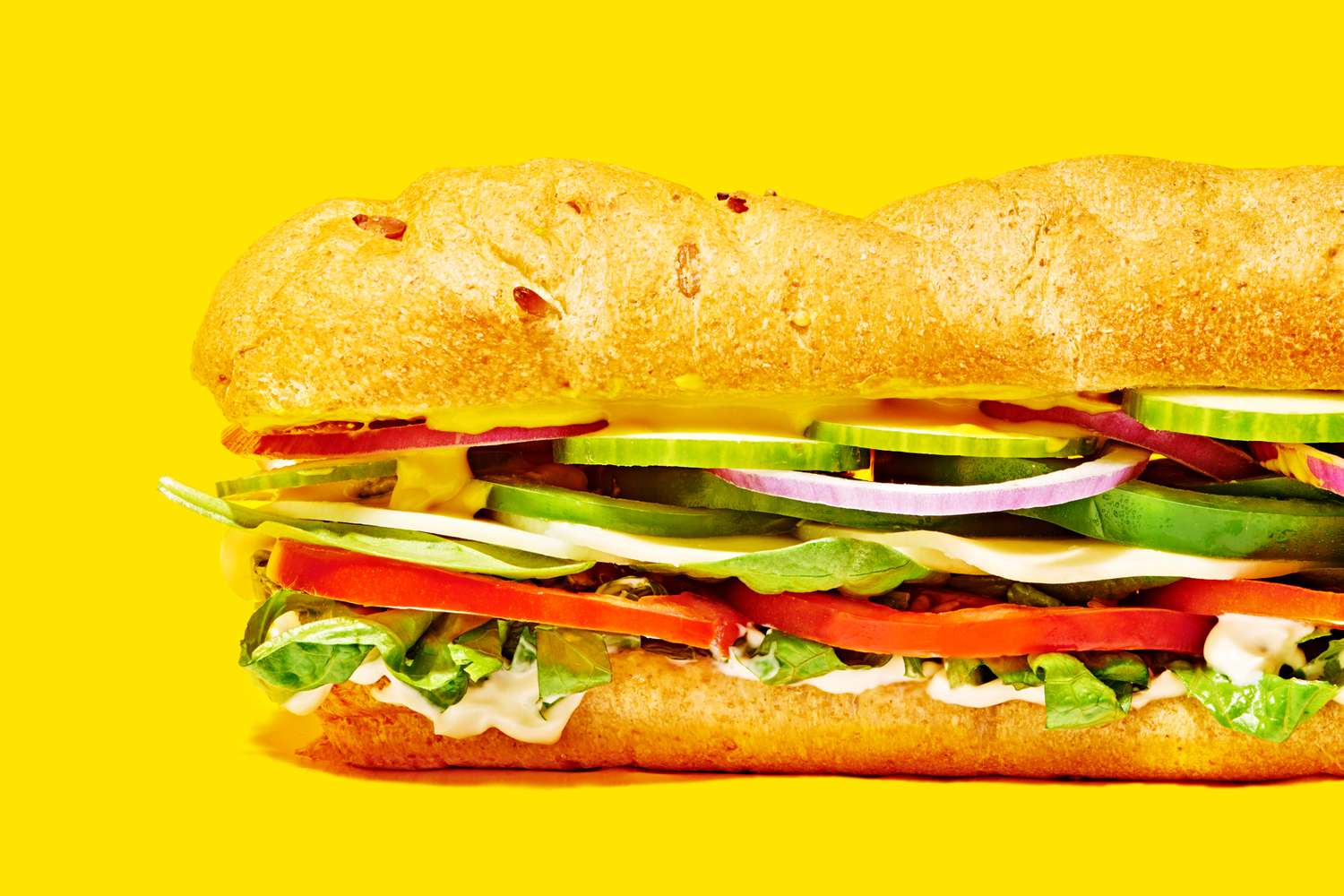 A sub sandwich on a yellow surface and background