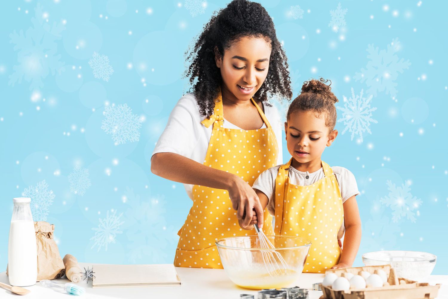 A woman and her daughter baking together with snowflakes in the background