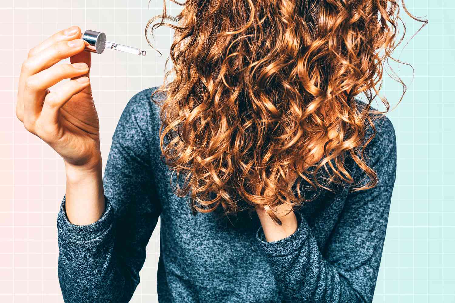 Woman with a oil dropper next to her healthy hair on a designed background