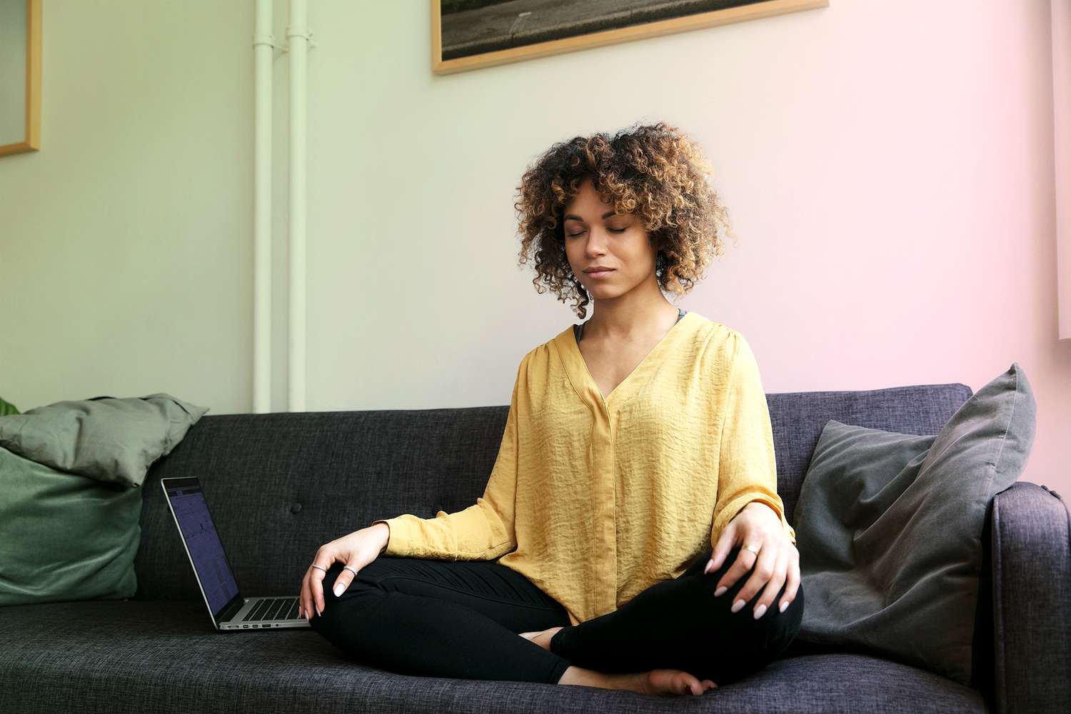 A woman sitting on a couch meditating