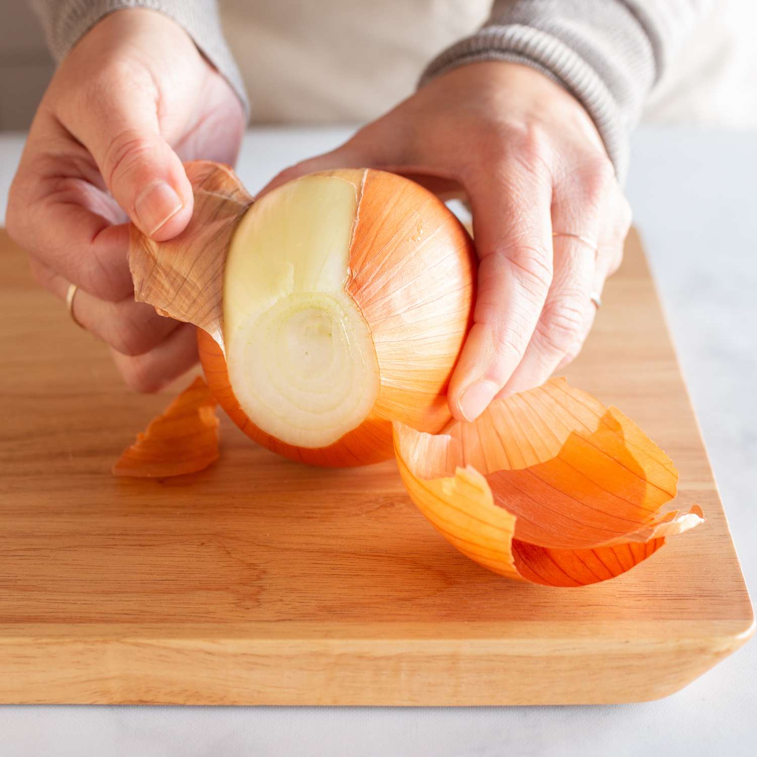 close up of hands peeling an onion