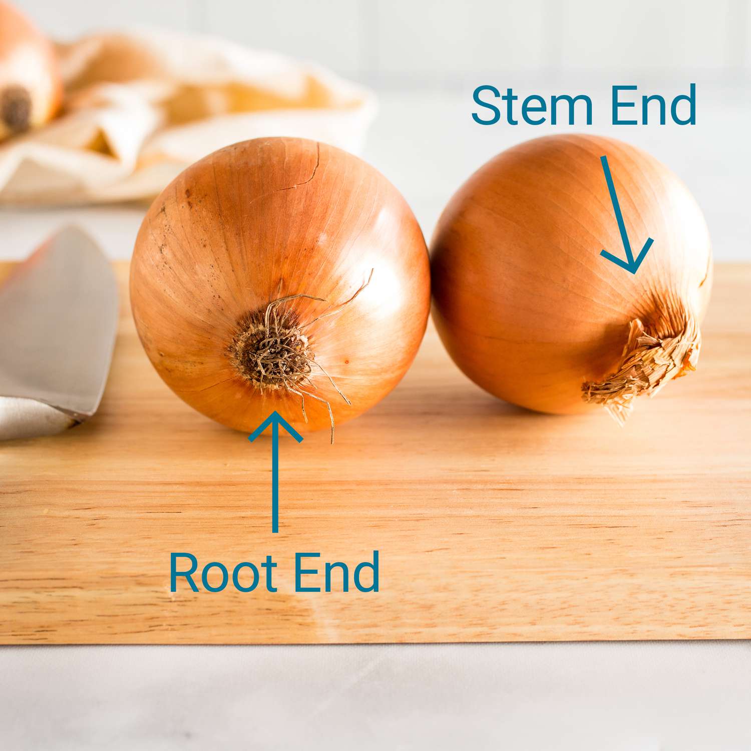 two onions resting on a cutting board at eye level