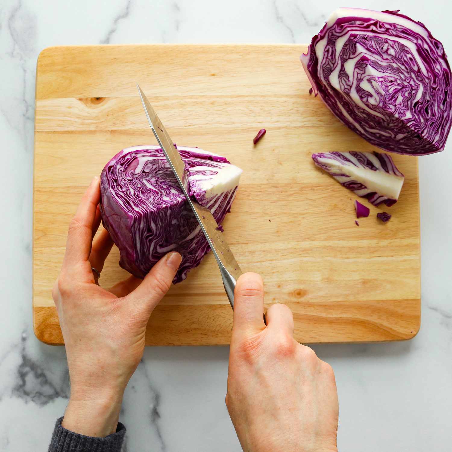 Close up of cutting the core off a quarter of a head of purple cabbage