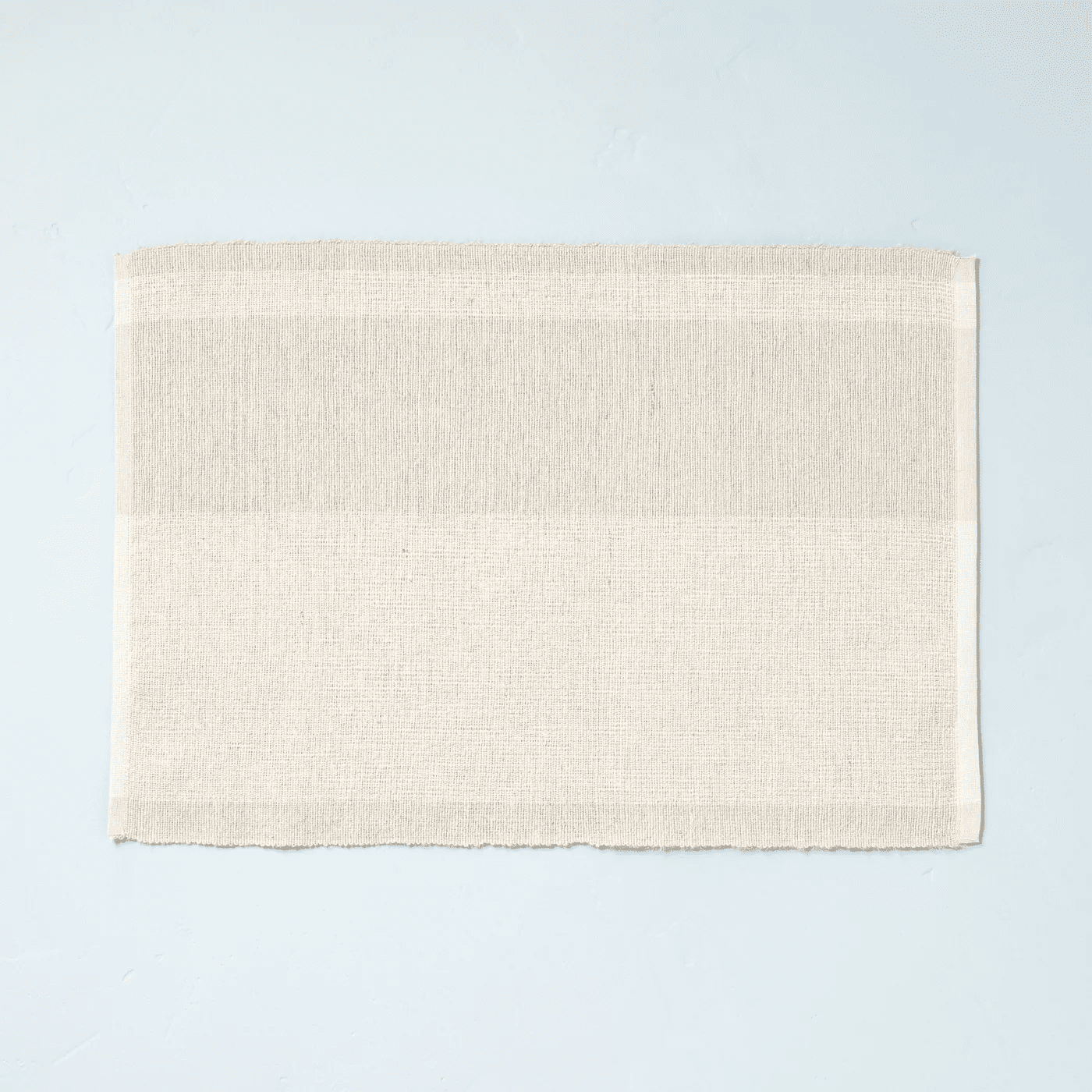 white and beige placemat on blue backdrop