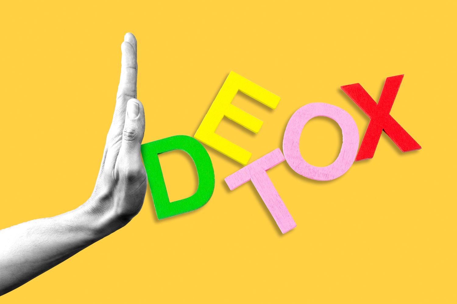 A hand pushing letter blocks that spell out "detox"