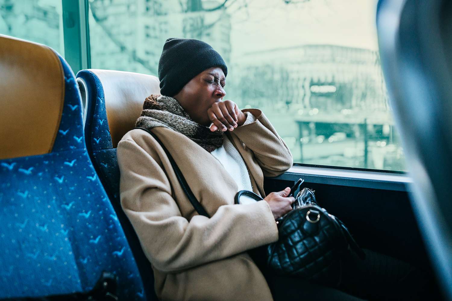 Yawning young woman traveling by bus