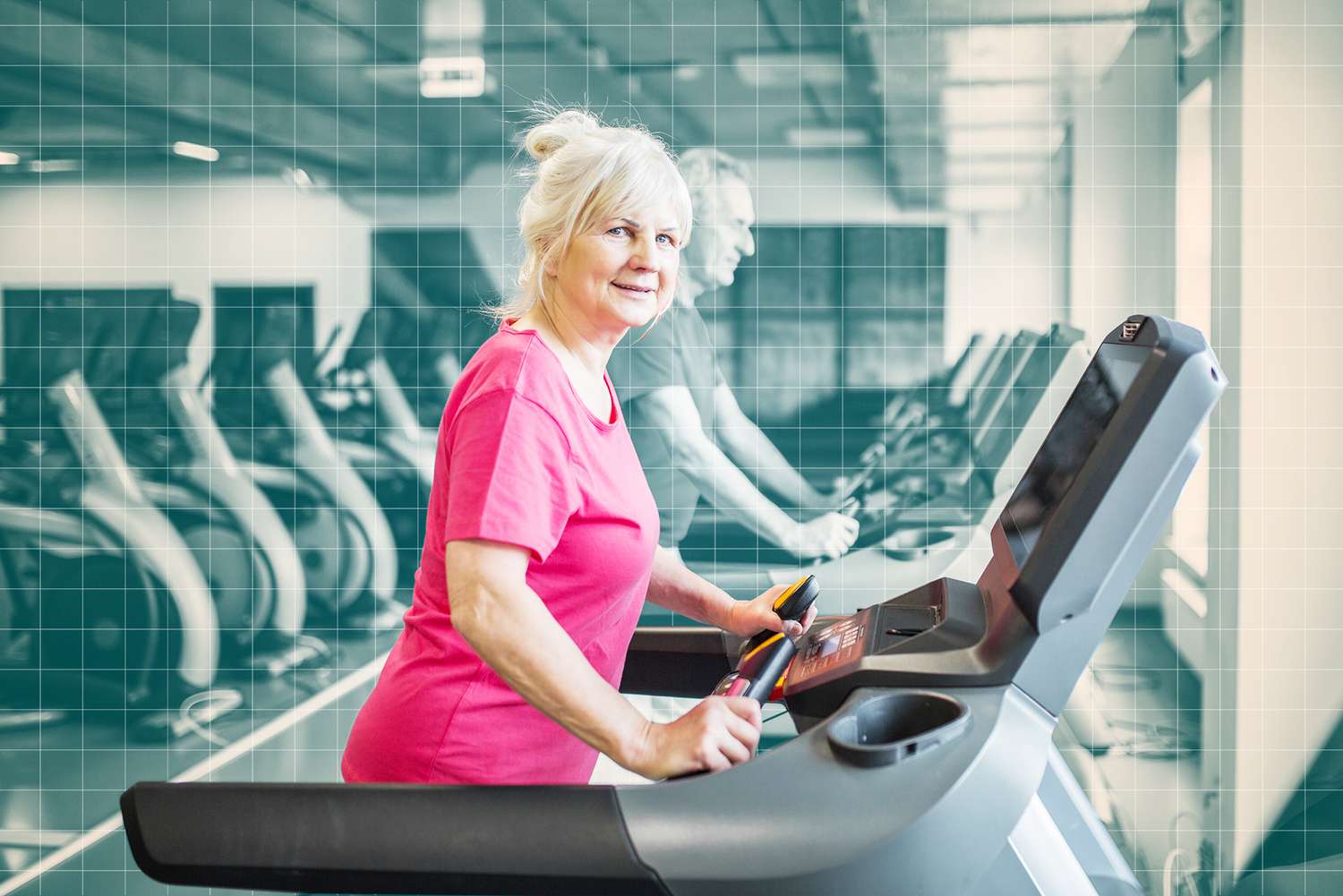 Smiling senior lady walking on treadmill at gym