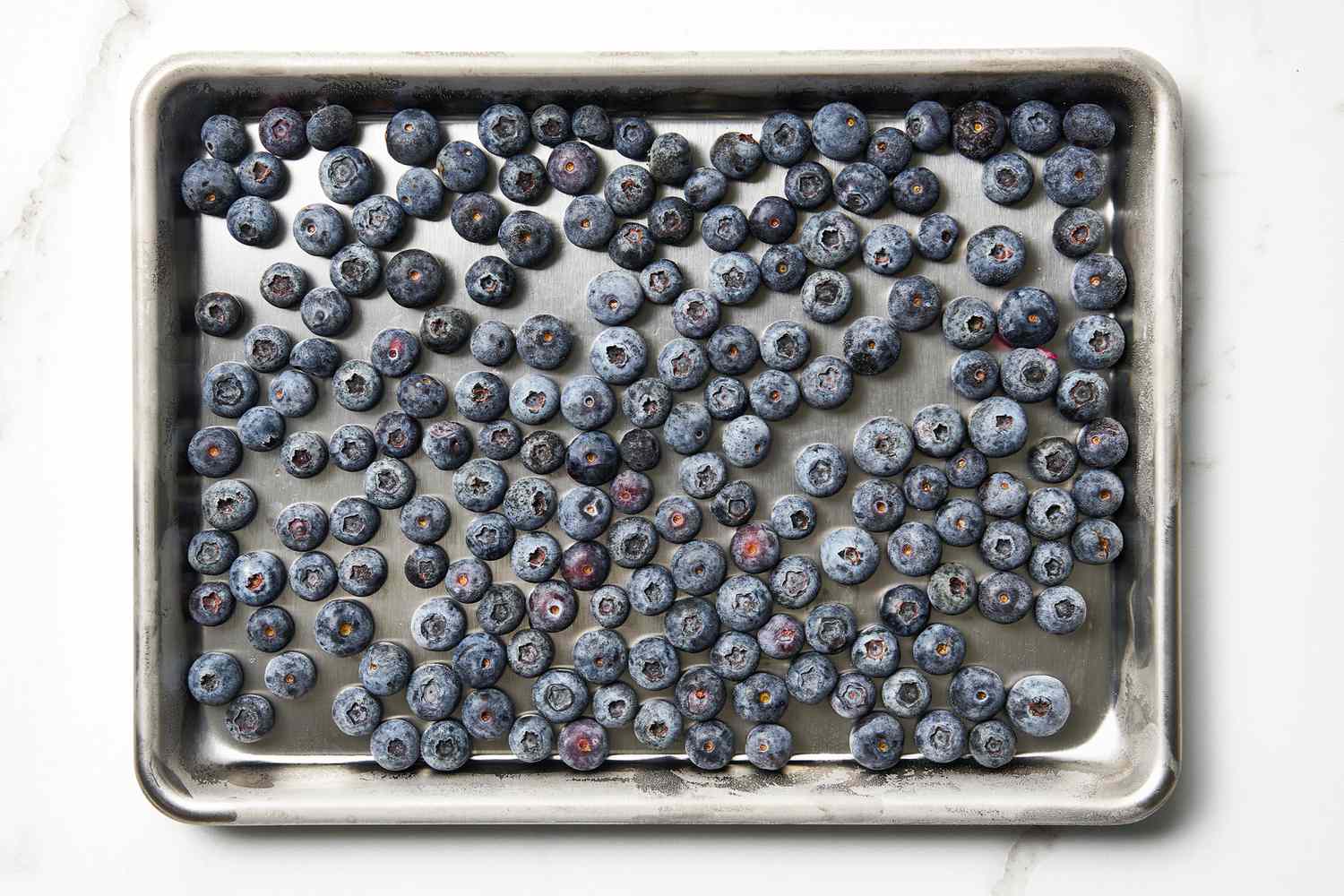 Frozen blueberries on a baking sheet