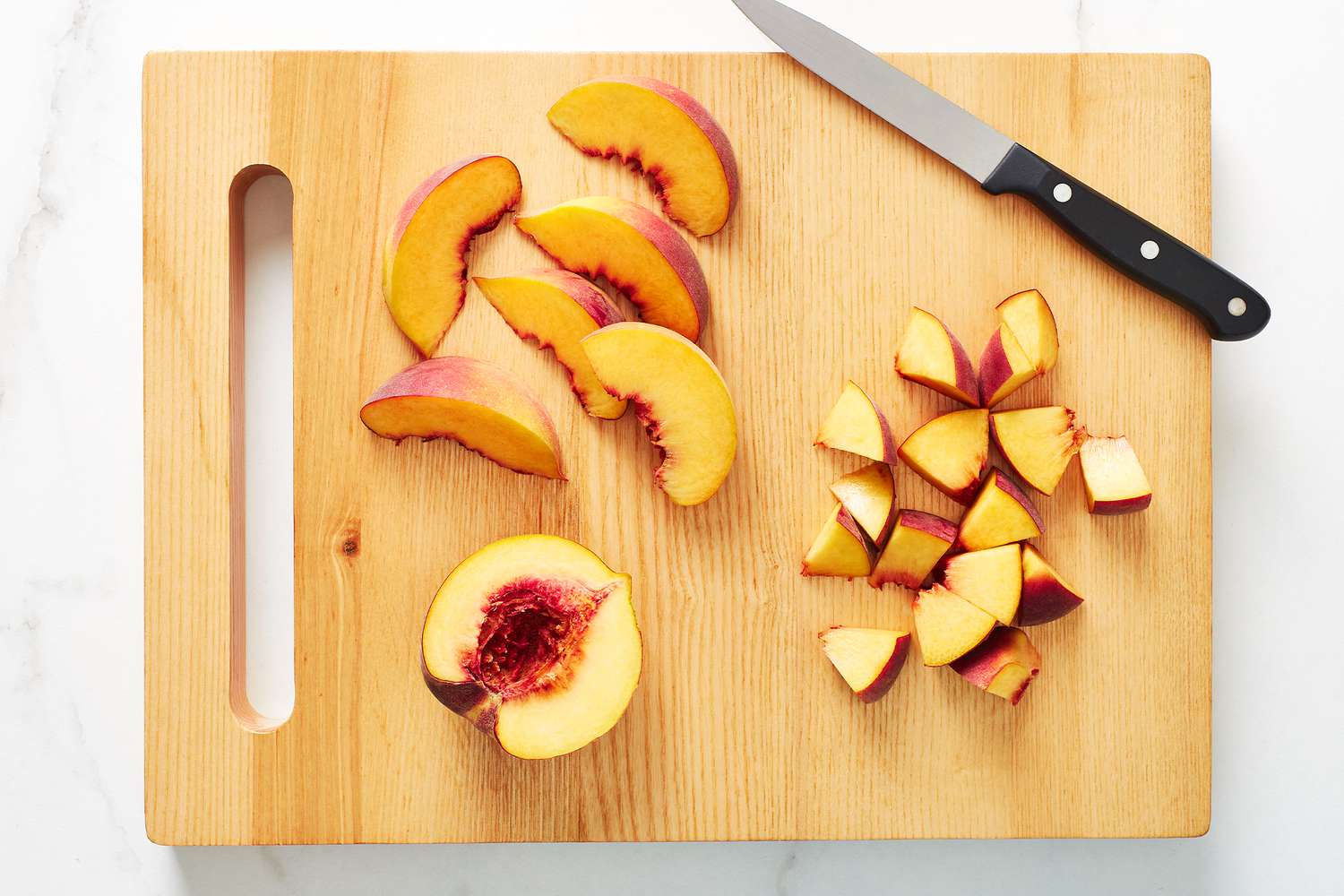 Peaches on a cutting board with a knife