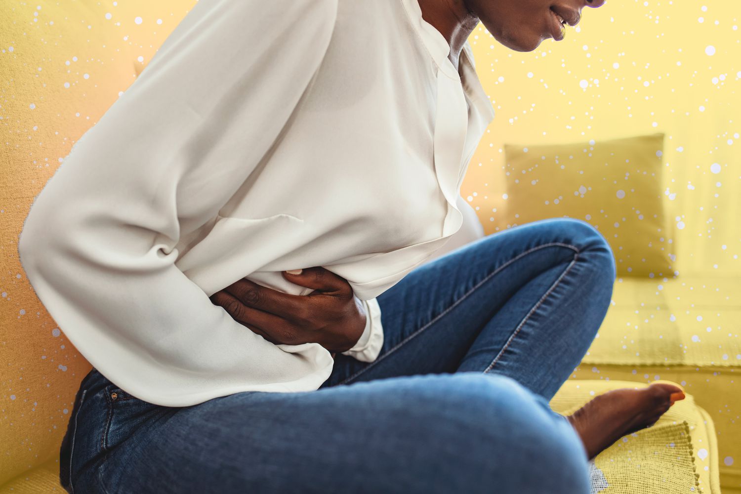 person crouching over with stomach pain on a designed background