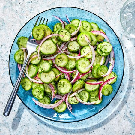 Cucumber salad in a light blue bowl