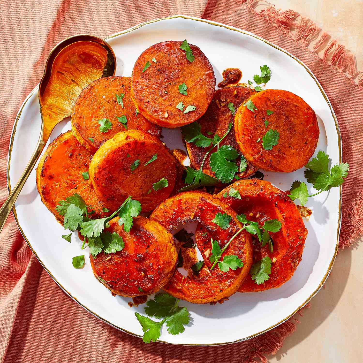 a recipe photo of the Melting Butternut Squash with Cumin & Cilantro on a serving platter and with a serving spoon