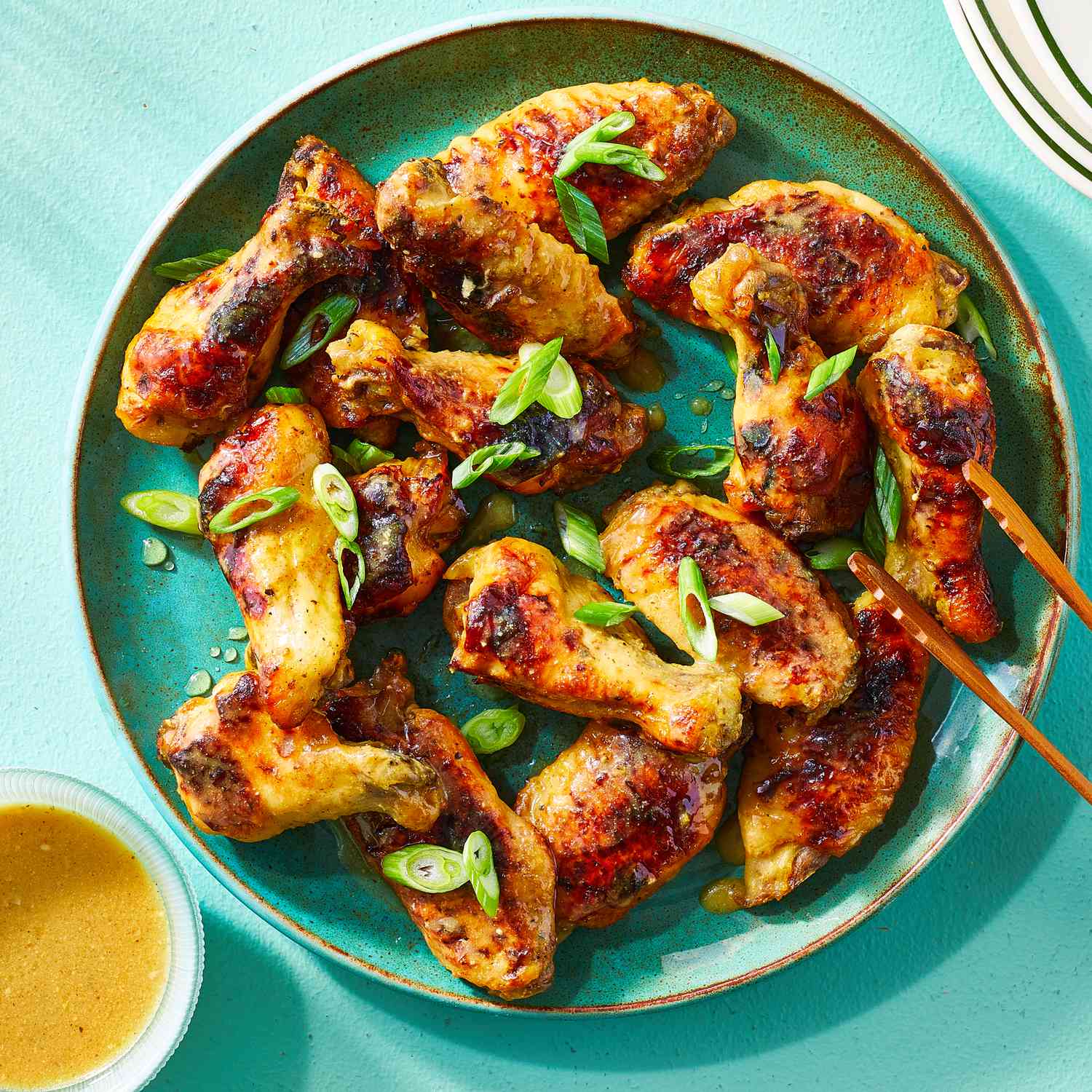 a recipe photo of Slow Cooker Wings served on a plate with sauce and green onions