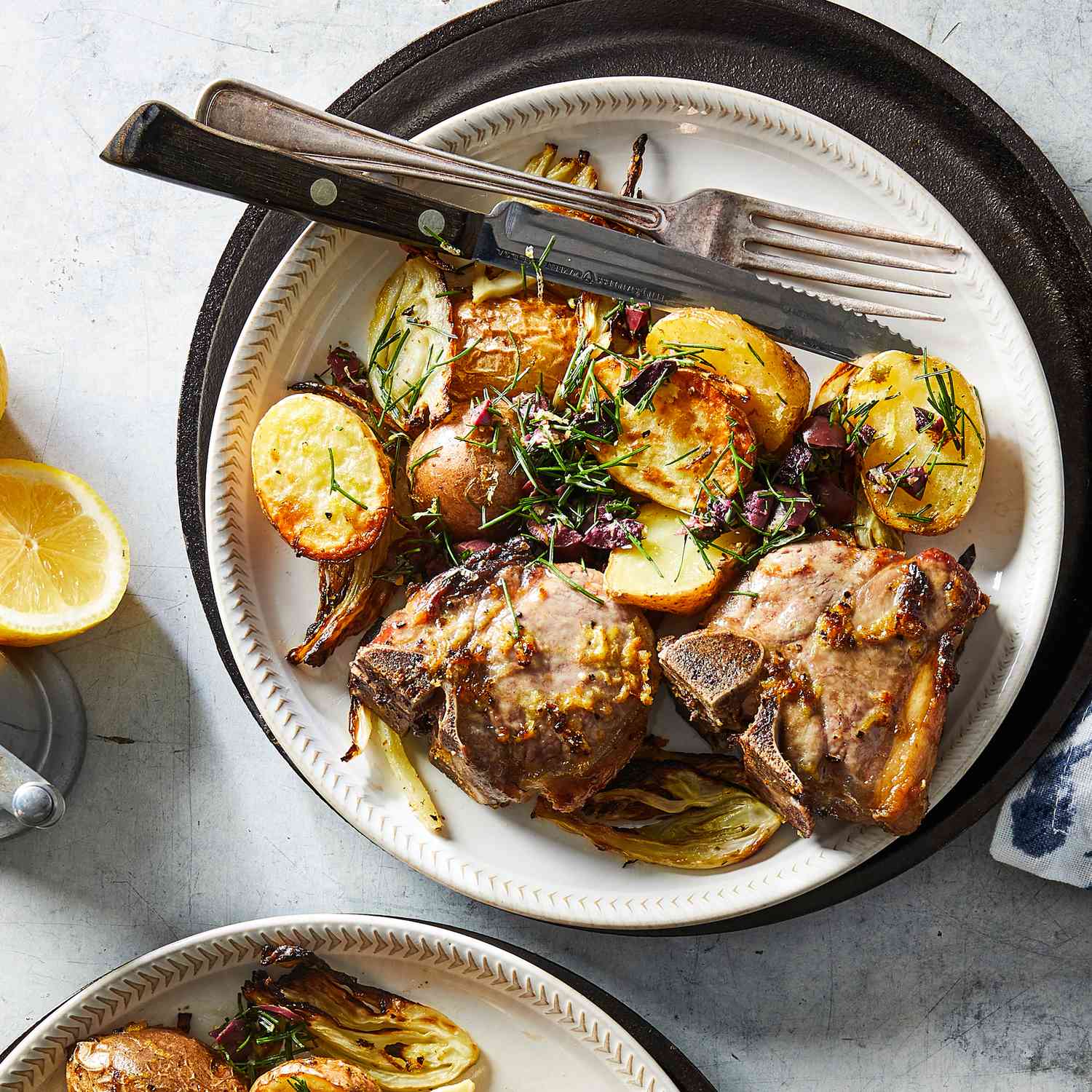 a recipe photo of the Air-Fryer Lemony Lamb Chops with Fennel & Olives served on plates