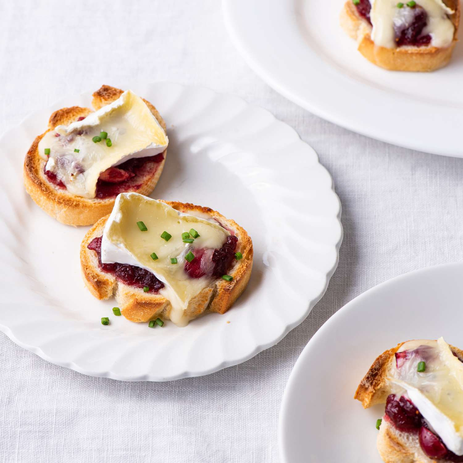 the recipe photo of the 3-Ingredient Cranberry-Brie Crostinis served on small plates