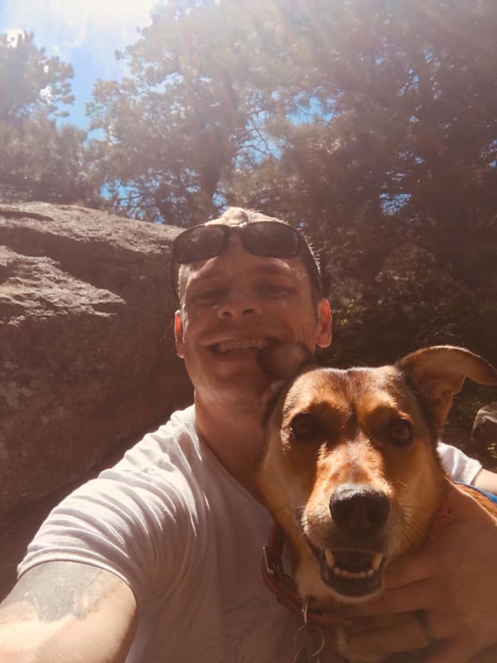 Smiling dog and owner take a selfie during a hike