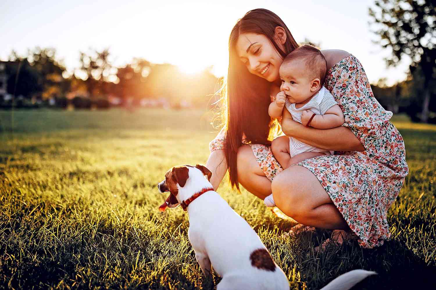 woman holding baby near dog