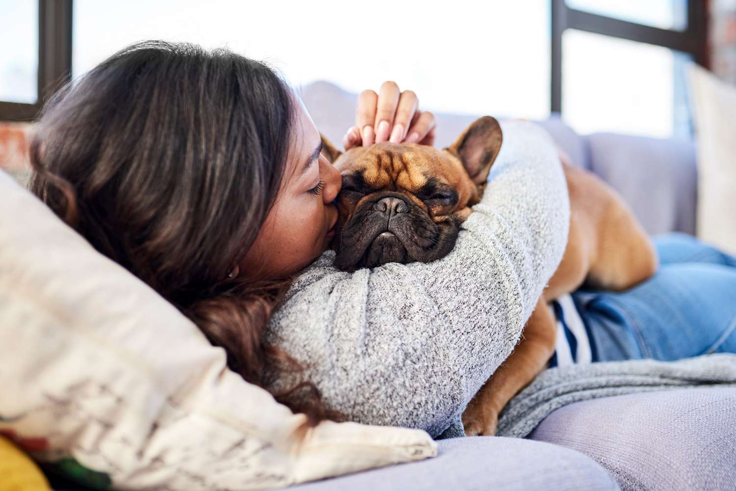 woman laying with her dog and hugging him