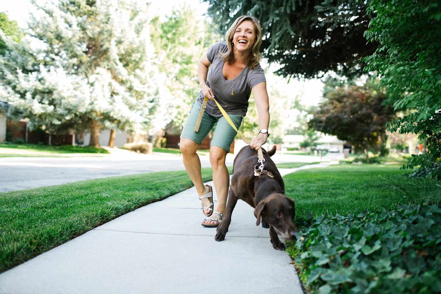 woman walking her dog in the neighborhood to be eco-friendly by not driving to a dog park