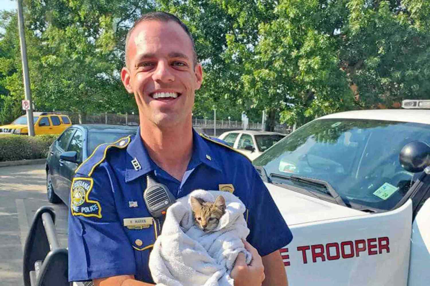 state police rescues kitten from bridge shown holding the kitten in a blanket