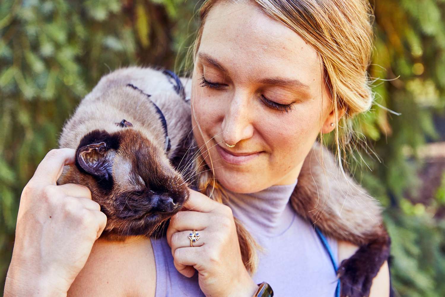 cat on woman's shoulder enjoying her affection; cats make great pets per science
