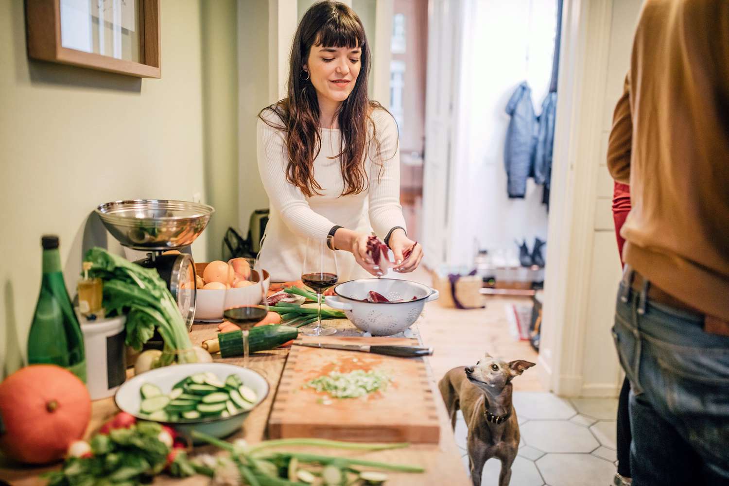 woman preparing Thanksgiving meal with her dog looking on
