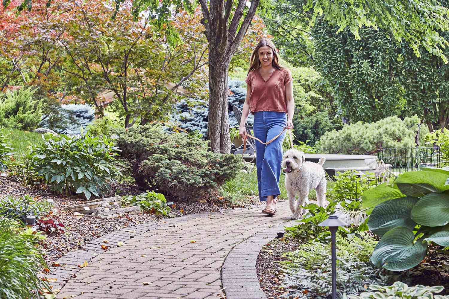 woman walking dog in a park; pet resolutions for 2023