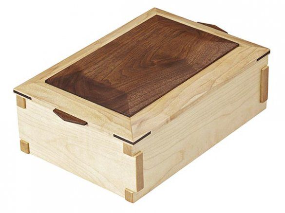Rectangular wood box. Beveled top with darker stain. Decorative corners.