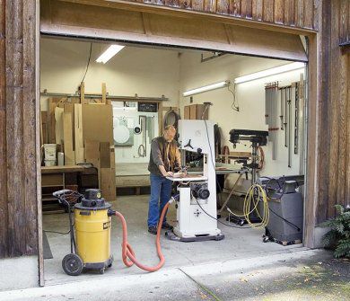Dale standing in his garage door entrance while working with a bandsaw.