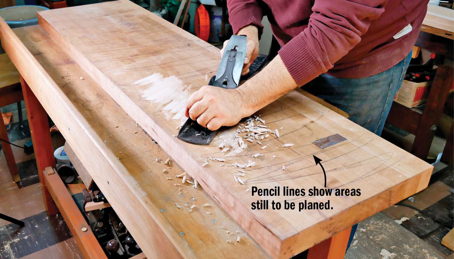 Photo of hand plane leveling a workbench top