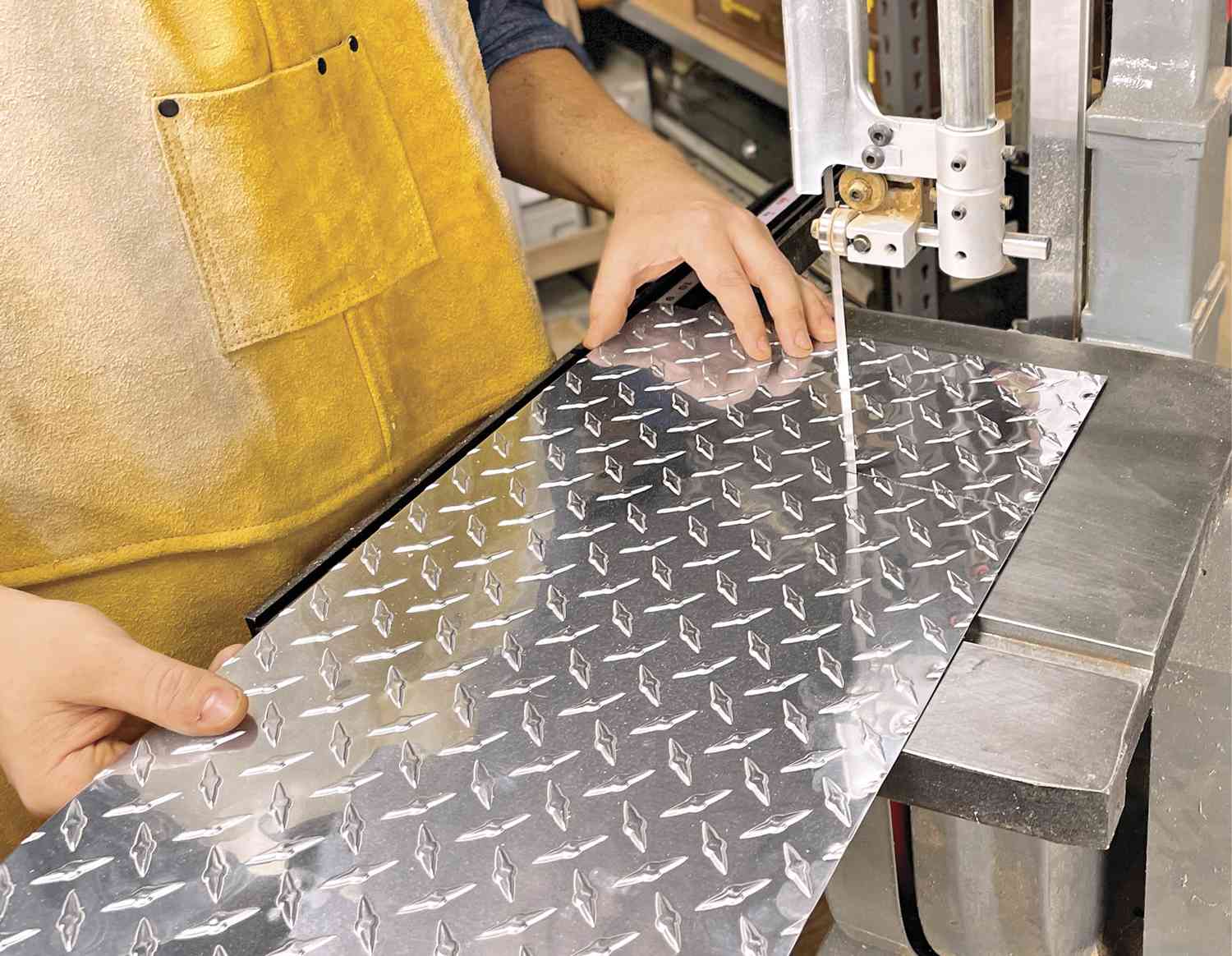 Phot of bandsaw cutting diamond plate metal