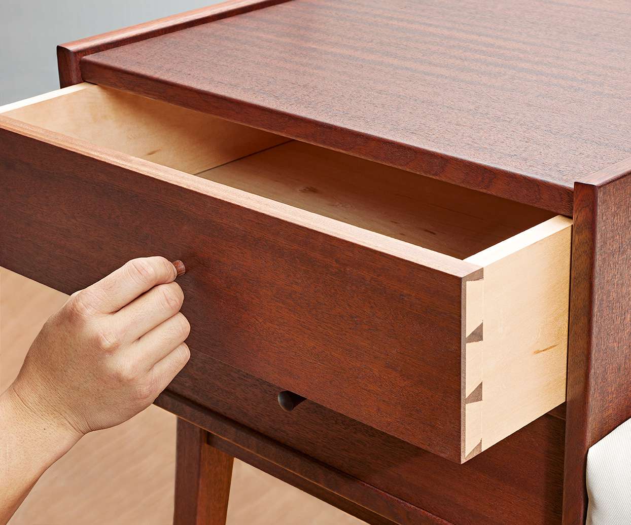 Hand pulling drawer out of cabinet