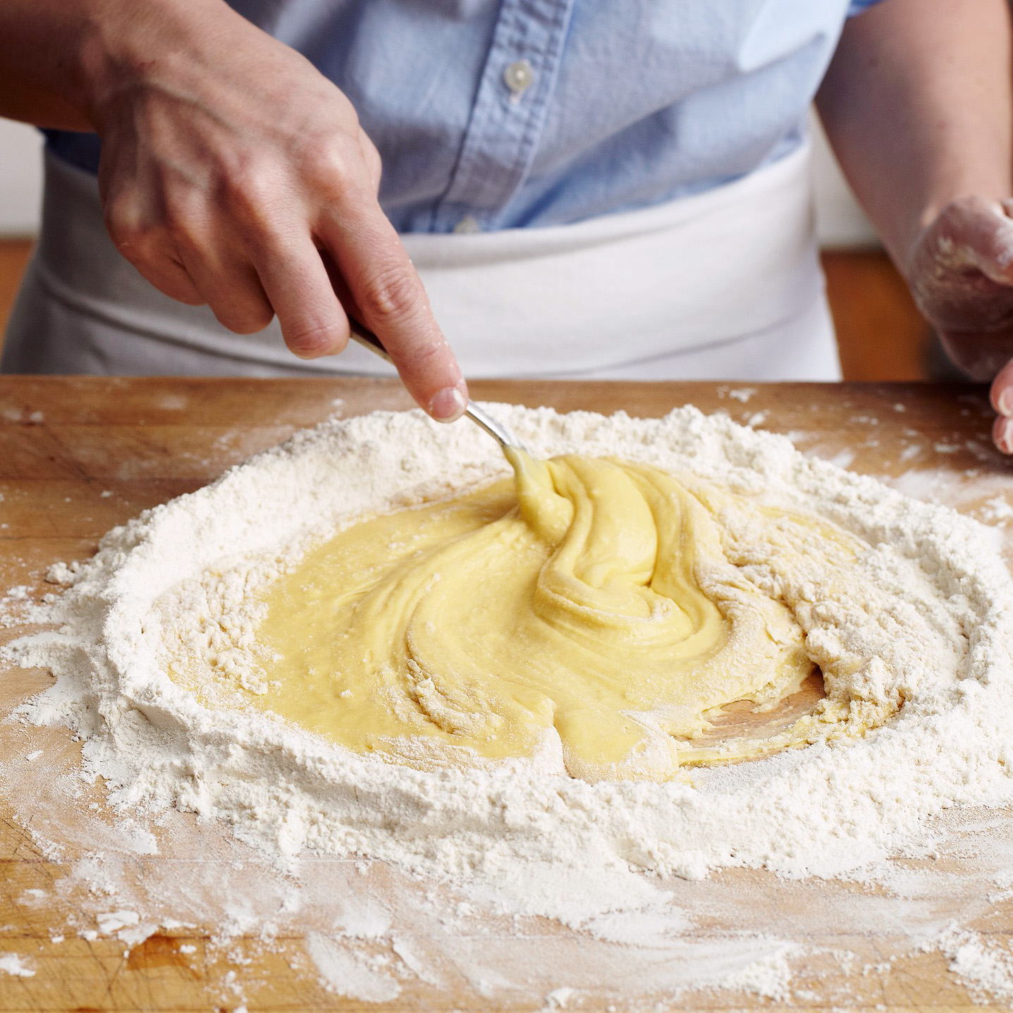 mixing eggs and flour together to form pasta dough