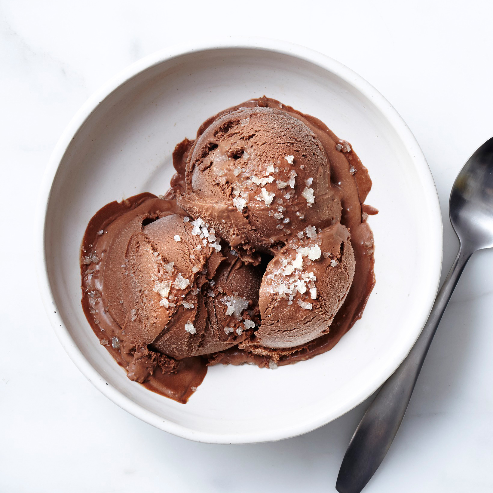 chocolate ice cream scoops in bowl topped with sea salt