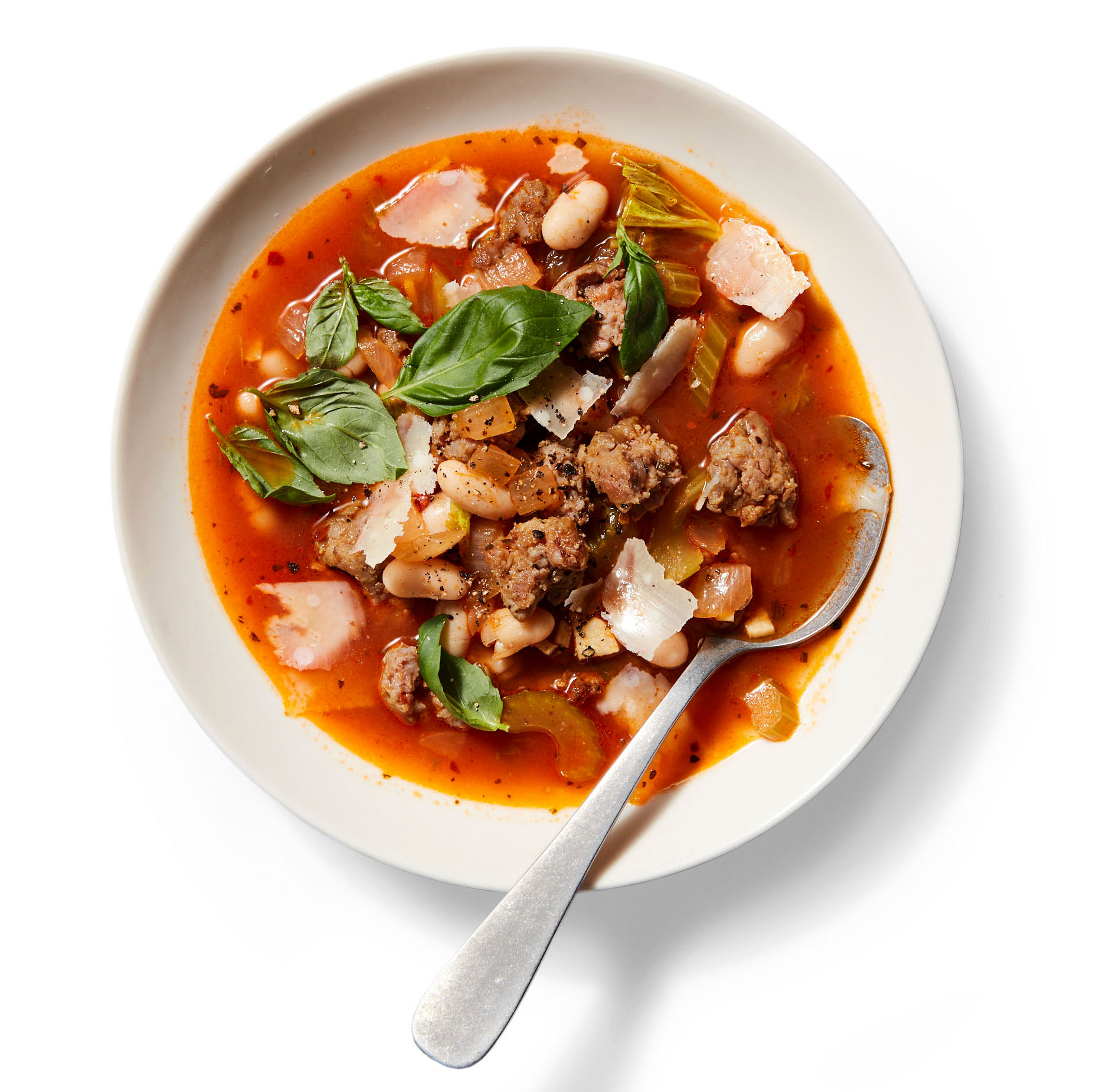 Italian sausage and bean soup in white bowl
