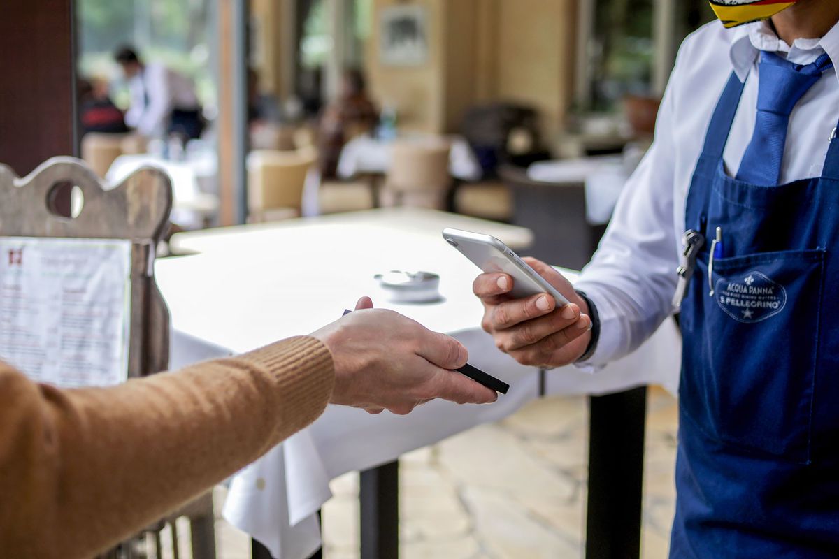 Restaurant worker checks diner's vaccination status