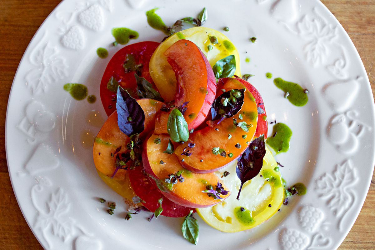 An heirloom tomato and stone fruit salad with basil oil