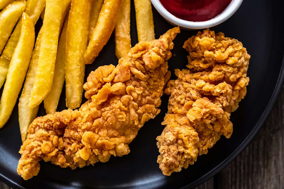 Fried chicken tenders with French fries and ketchup on a plate