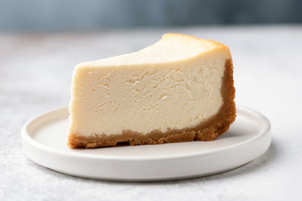 Slice of classic cheesecake on a white dessert plate